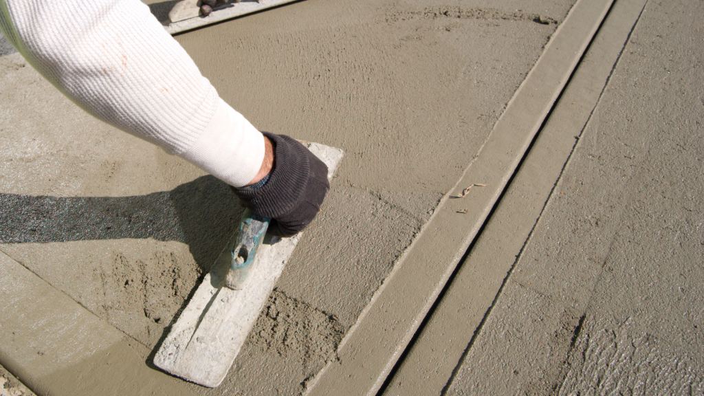 Concrete contractor finishing a sidewalk during installation for a residential or commercial property